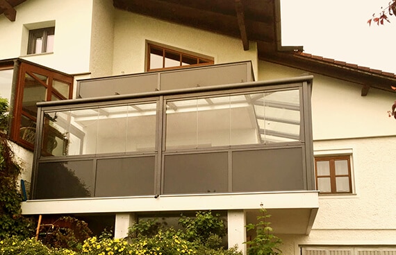 Balkonverglasung inkl. Glasgeländer in Oberösterreich an einem Wohnhaus mit Glasdach