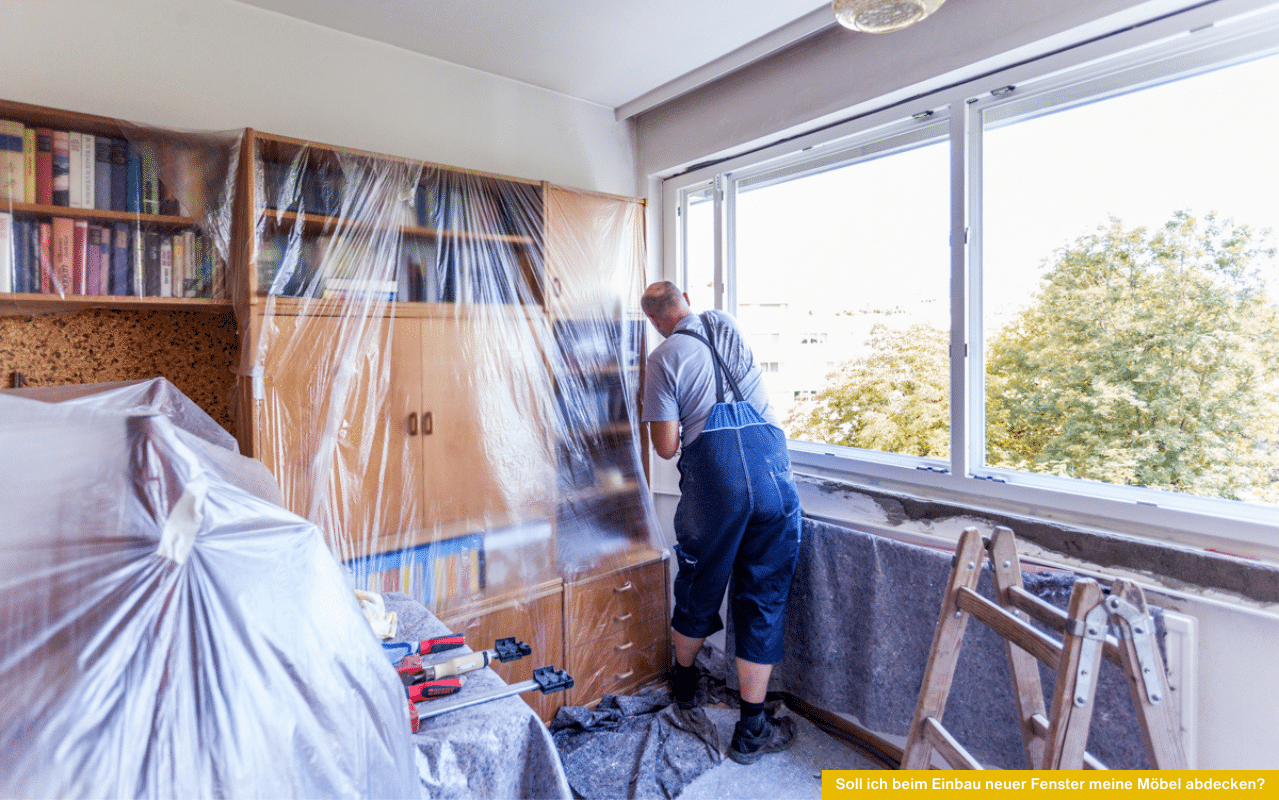 Soll ich beim Einbau neuer Fenster meine Möbel abdecken? Monteur arbeitet am Fensterrahmen, Möbel im Raum mit Folie und Decken geschützt.