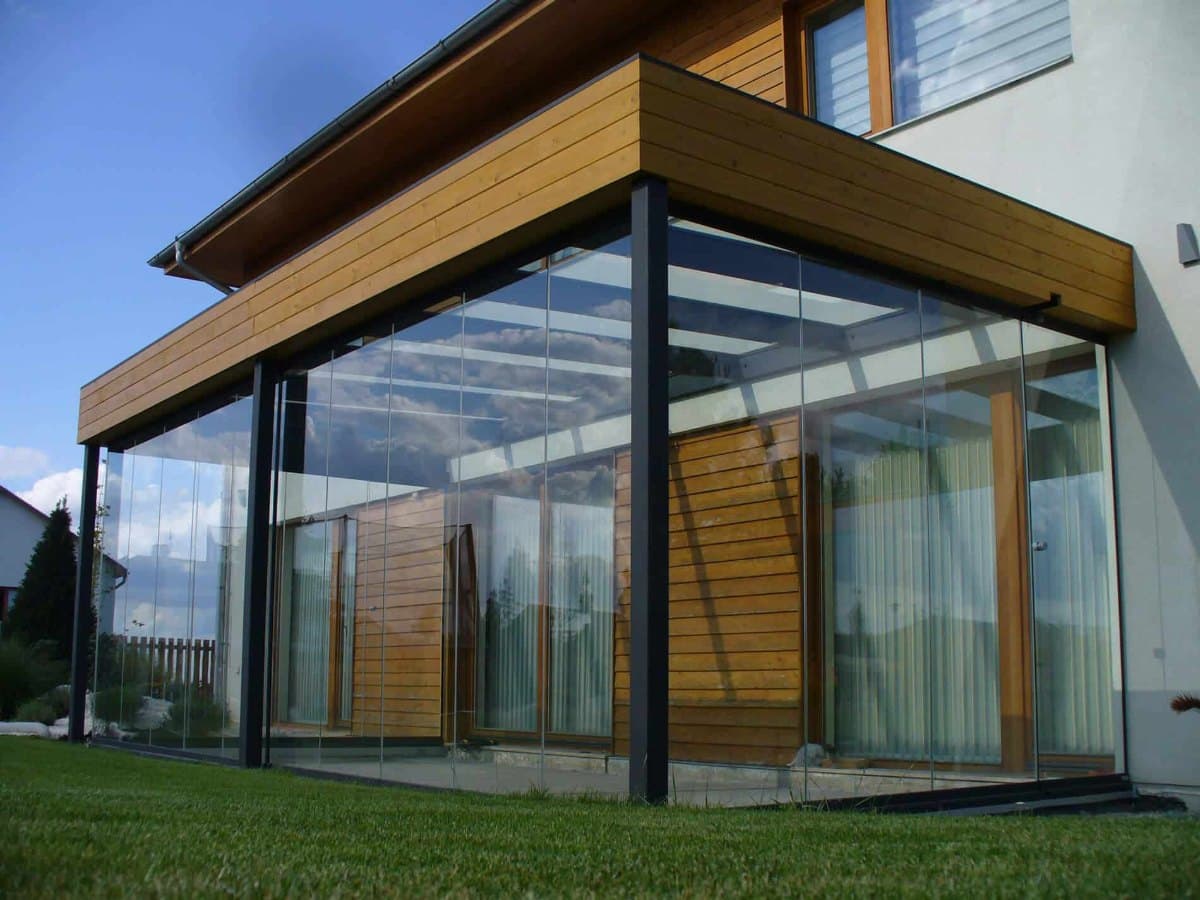 Sommergarten in RAL 7016 Anthrazitgrau mit Flachdach, Holzverkleidung an der Attika und Ganzglas-Schiebe-Dreh-System aus 10 mm ESG-H