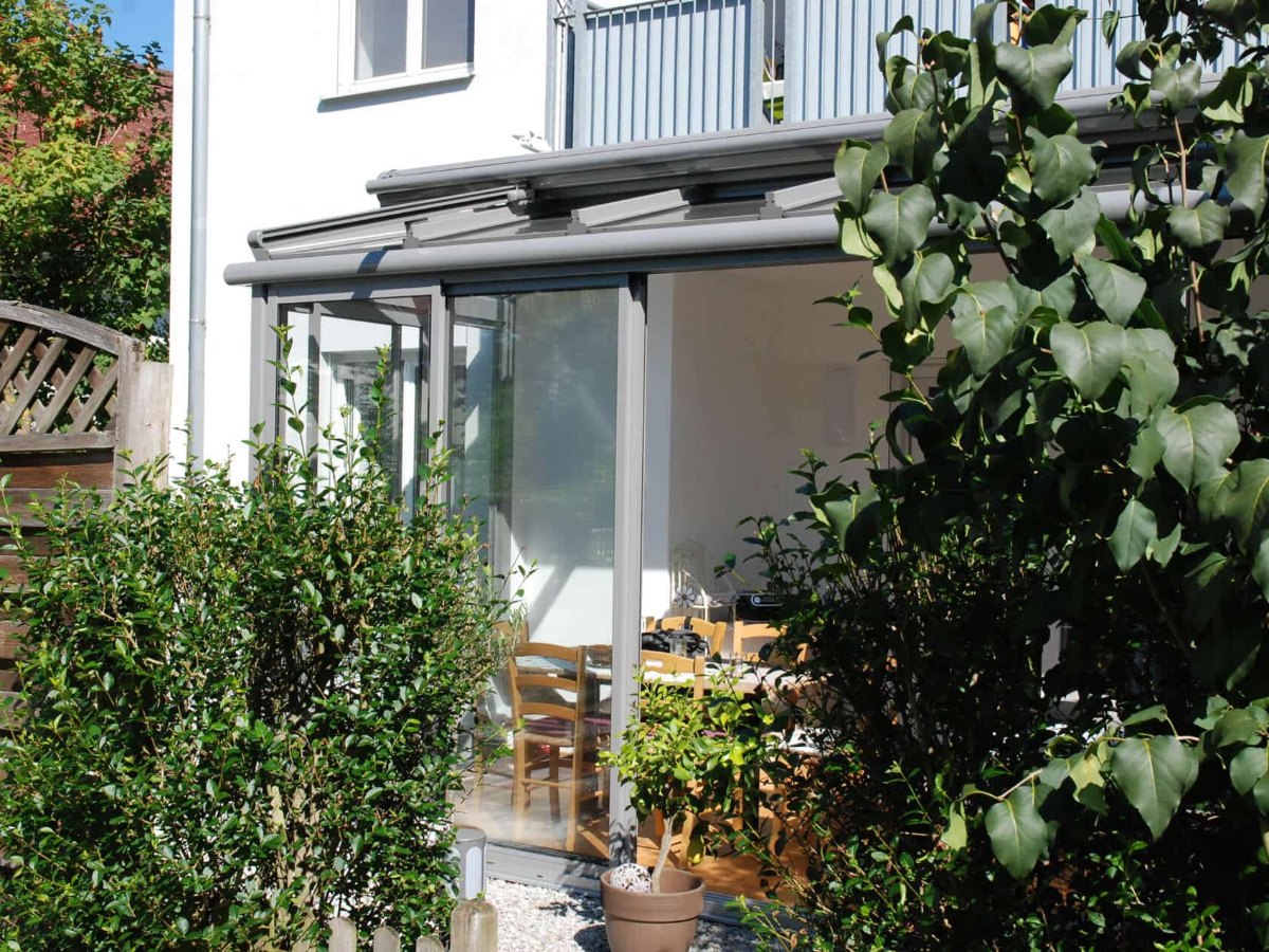 Sommergarten aus Aluminium in RAL 9006 Graualuminium mit gerahmten Schiebeelementen und Beschattung auf dem Glasdach, montiert in Oberösterreich