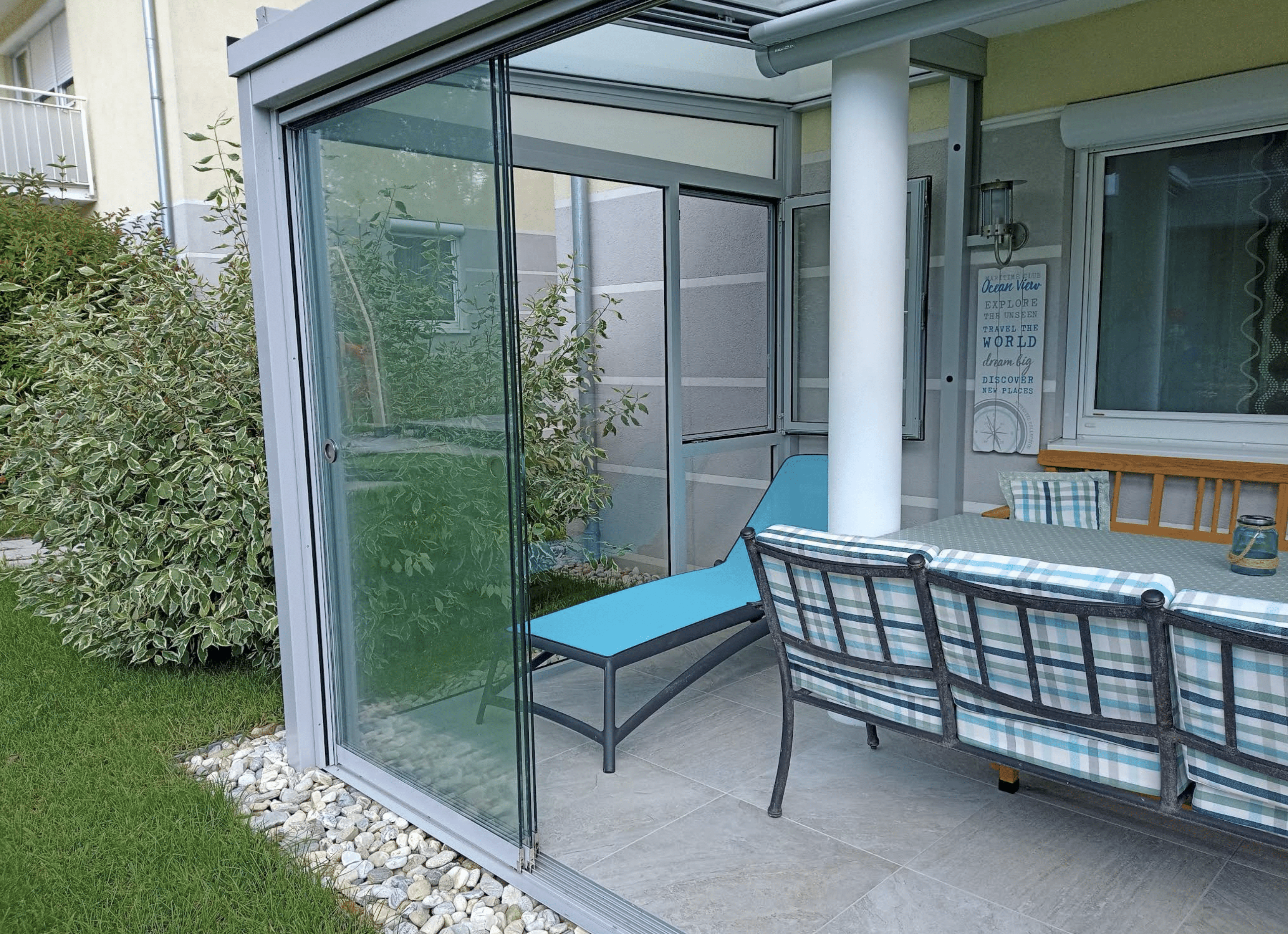 Geöffnete Ganzglas-Schiebetür mit Übergang zum Garten