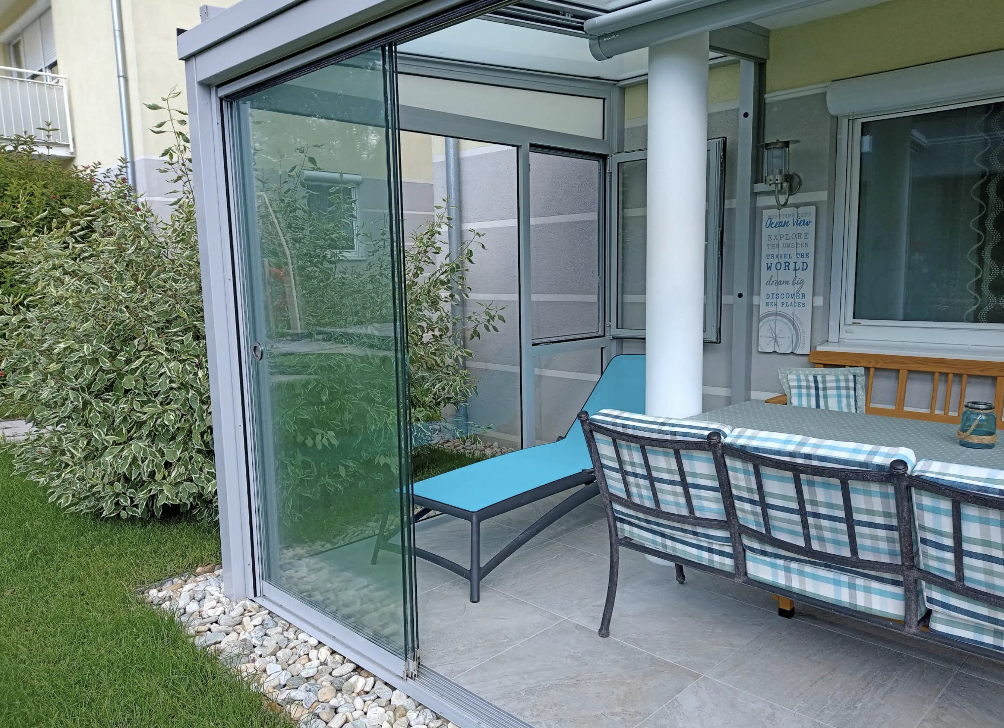 Geöffnete Ganzglas-Schiebetür mit Übergang zum Garten