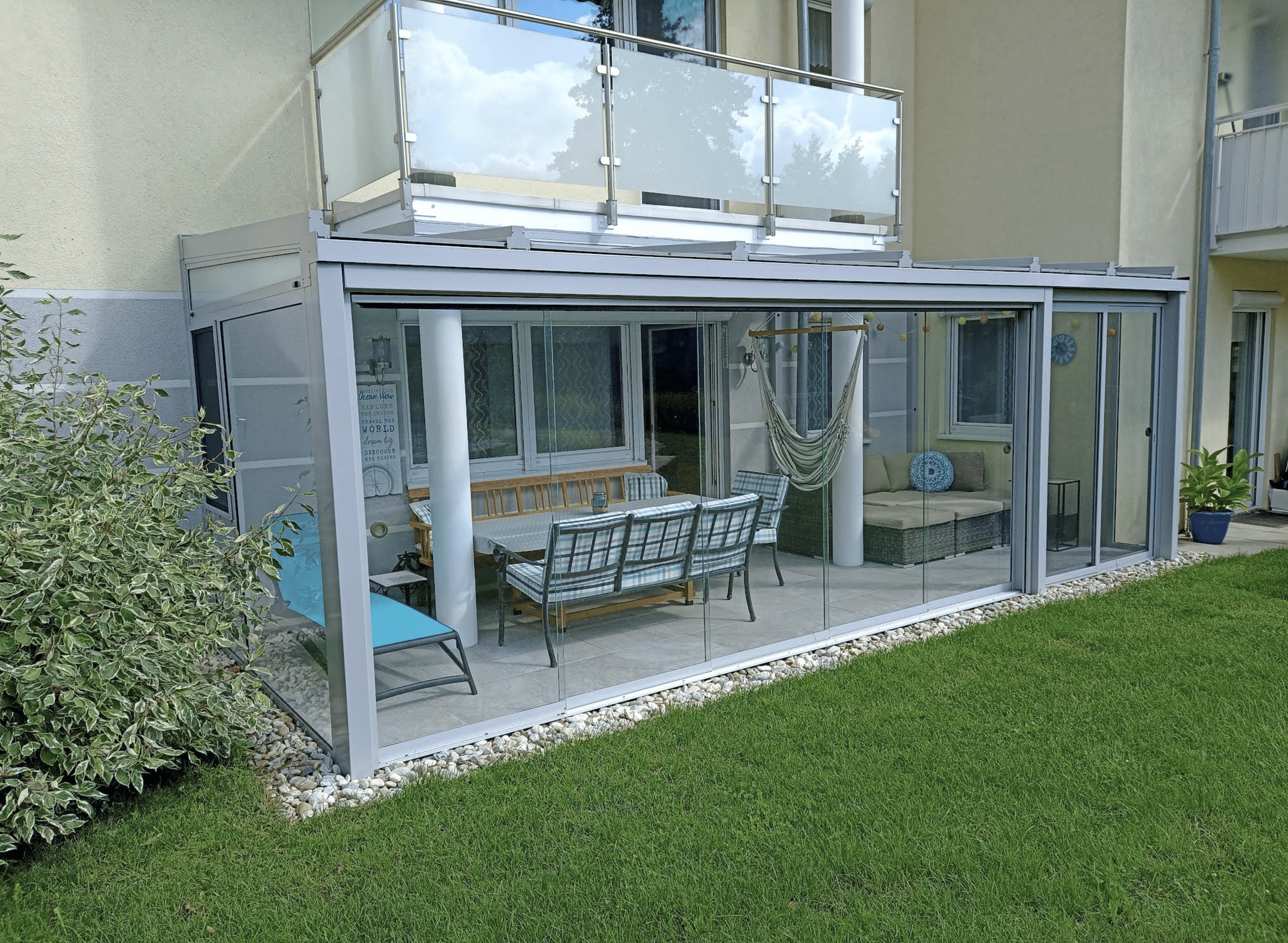 Sommergarten mit Glasdach und Ganzglas-Schiebewänden an einem Wohnhaus