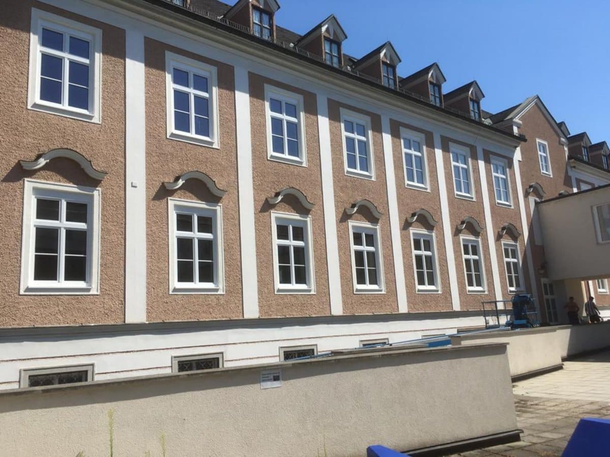 Großer Altbau mit weißen Sprossenfenstern über mehrere Geschoße