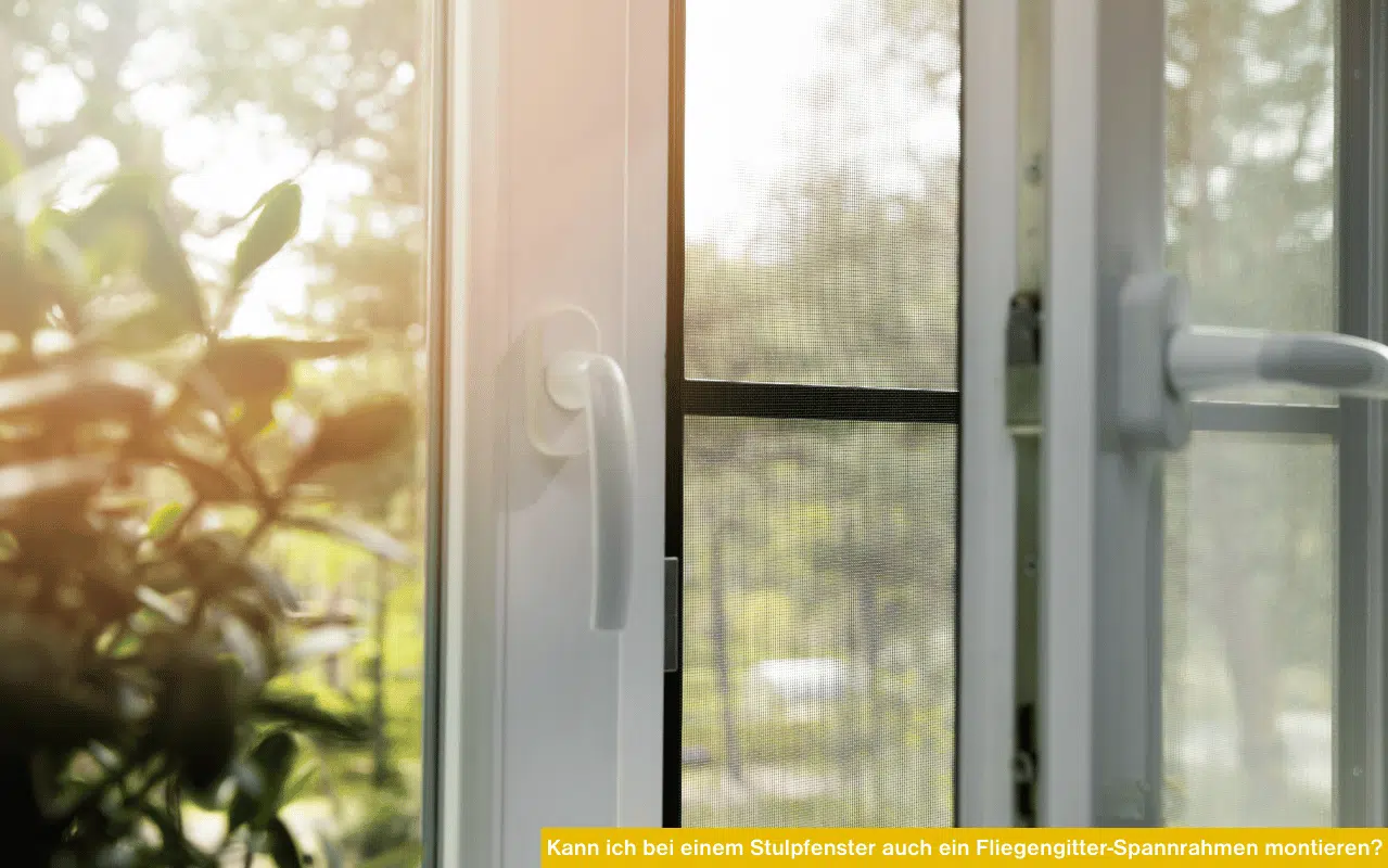 Ein weißes Fenster mit Insektenschutz-Spannrahmen gibt den Blick auf sonnendurchflutetes Grün im Garten frei.