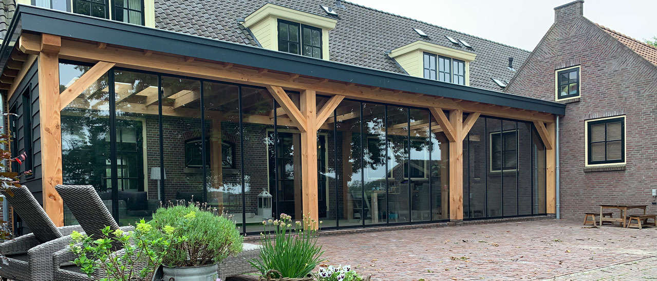 Moderne Terrassenverglasung. Sunflex Schiebe-Dreh-Systeme zum Falten SF35 schützen eine Holzkonstruktion.