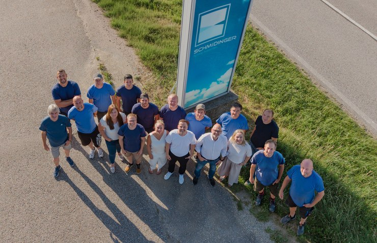 Das Team von Fenster Schmidinger aus der Vogelperspektive neben dem Firmenschild in Gramastetten