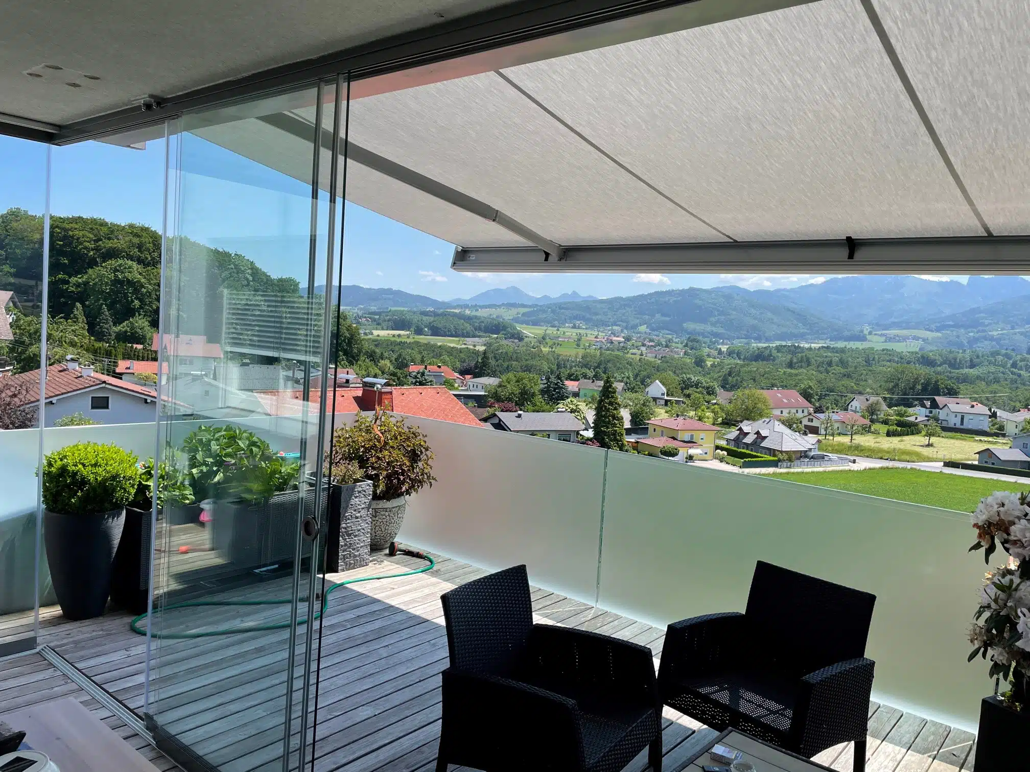 Terrasse mit Glasschiebewänden vor starken Wind- und Regen geschützt