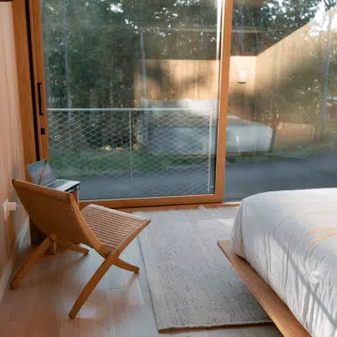 Terrassen Schiebetüren aus Holz verbinden Wohnraum mit Terrasse und sorgen für viel Tageslicht im Schlafzimmer