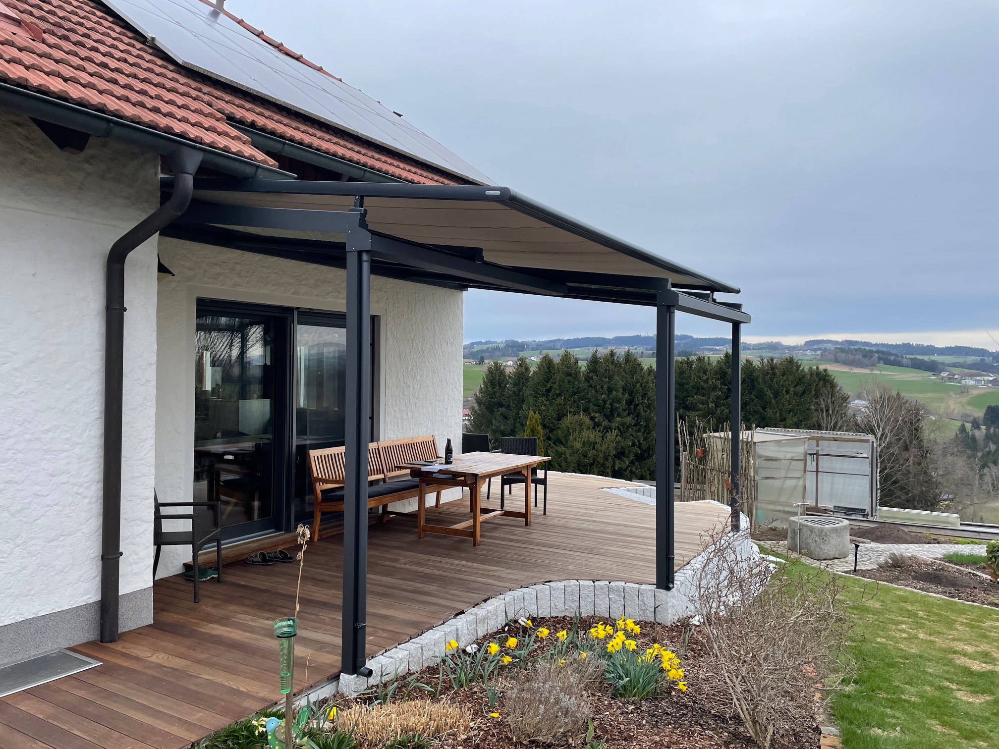 Terrassenüberdachung aus Alu mit unterschiedlichen Tiefen und Aufglas-Beschattung