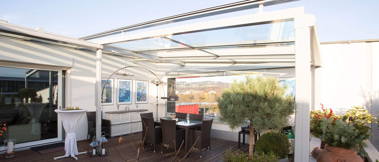 Terrassenüberdachung Farbe veranschaulicht harmonisches Design mit Glasdach und hellgrauer Konstruktion für stilvolle Outdoorbereiche.