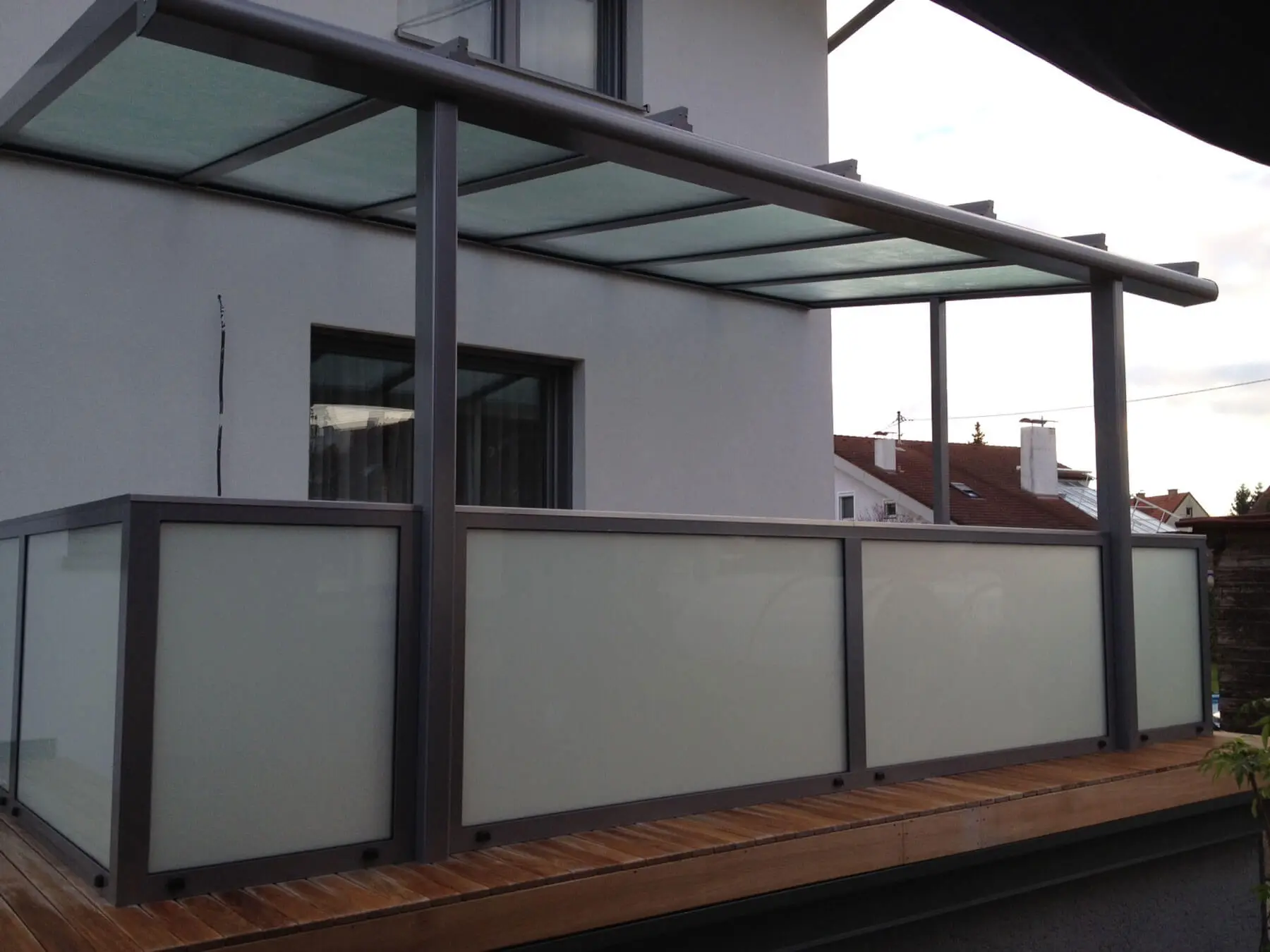 Terrassenüberdachung mit Geländer aus Alu & Milchglas