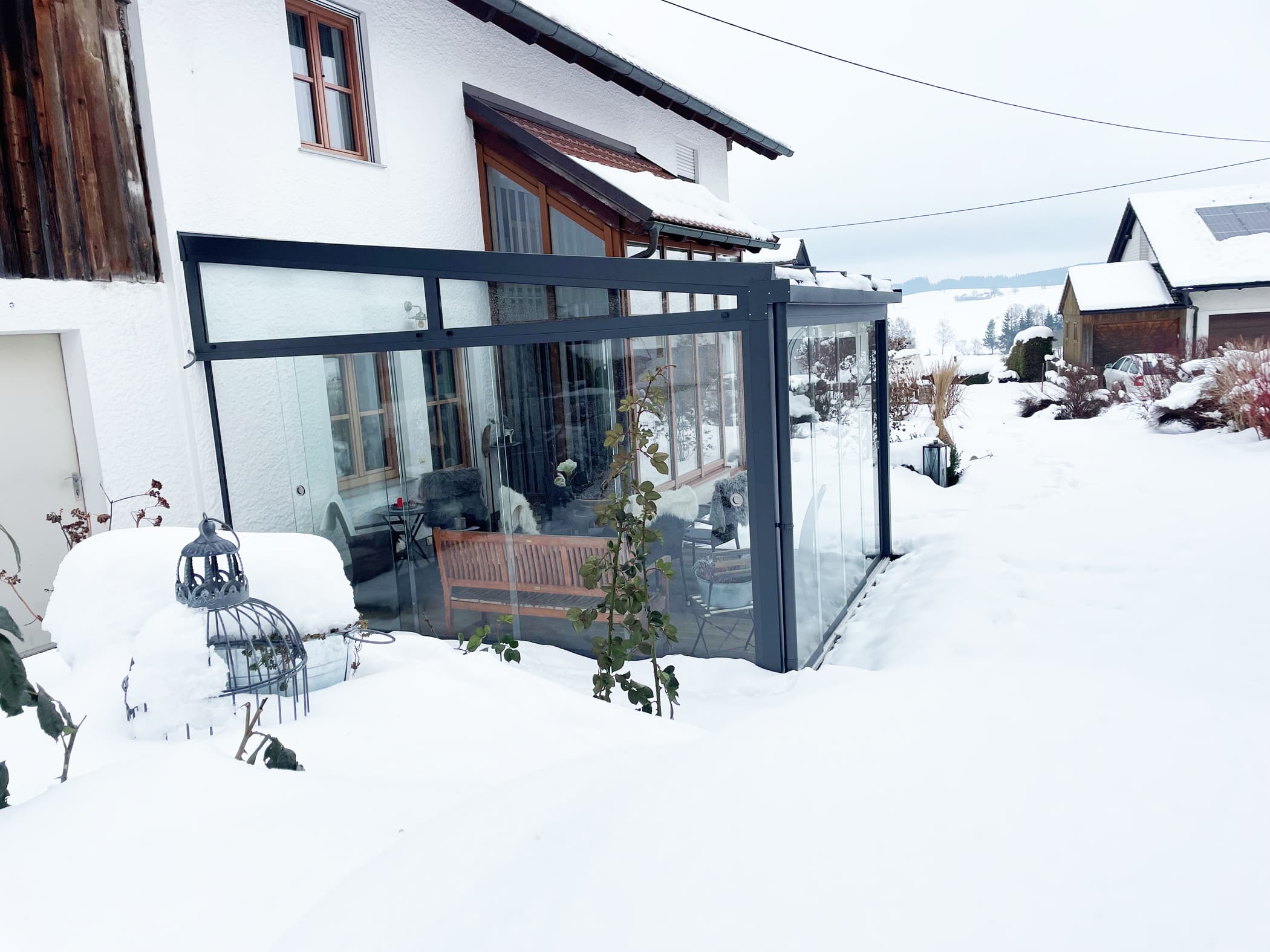 Terrassenüberdachung mit seitlichen Windschutz als Glasschiebeelementen