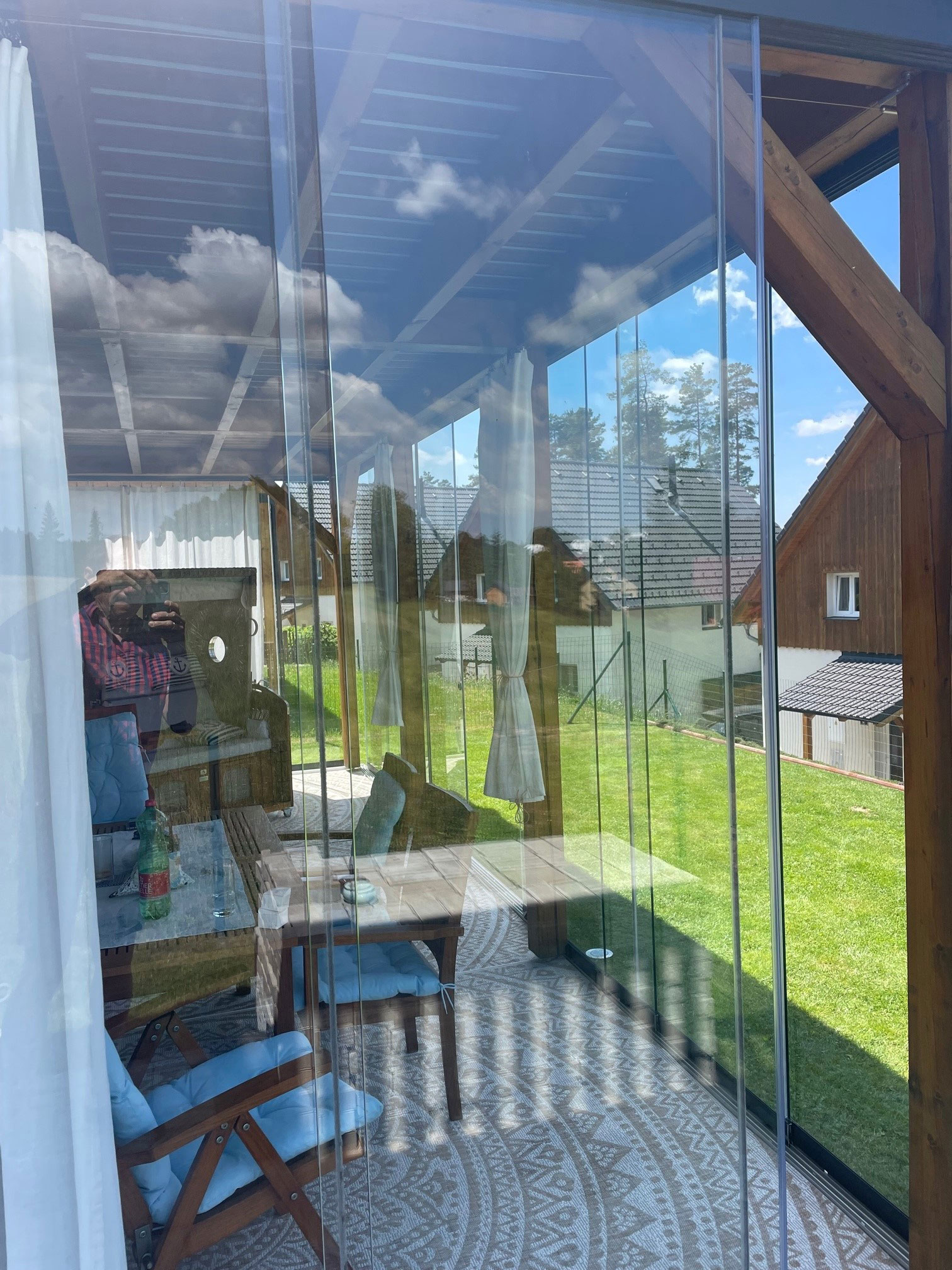 Terrassenumbau mit windgeschützten Glasschiebetüren