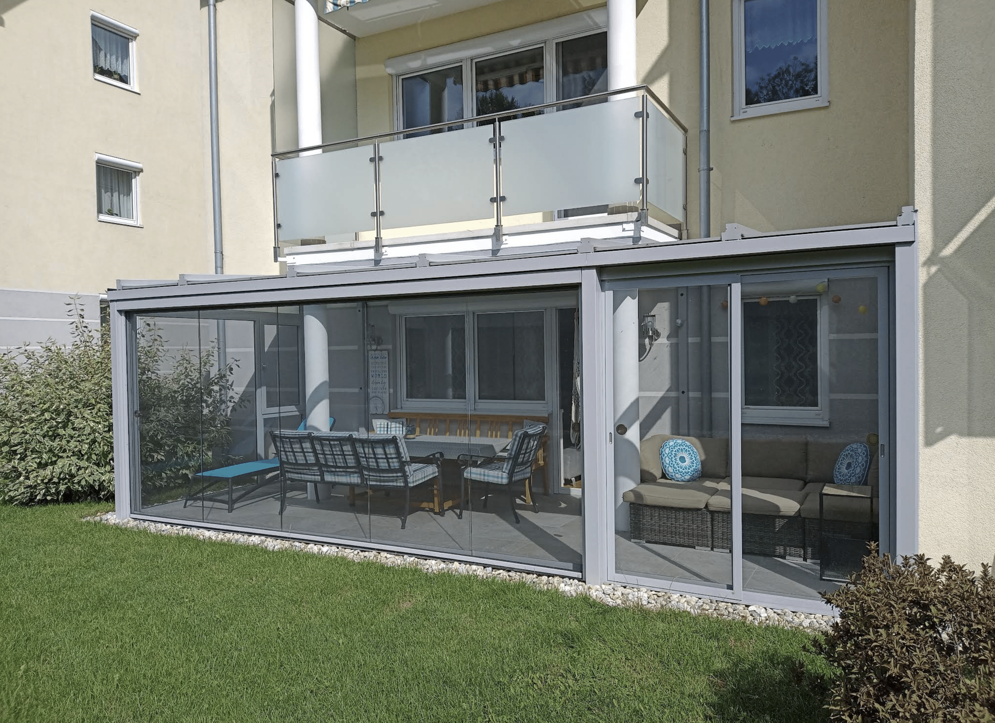 Terrassenverglasung passgenau unter einem bestehenden Balkon eingebaut