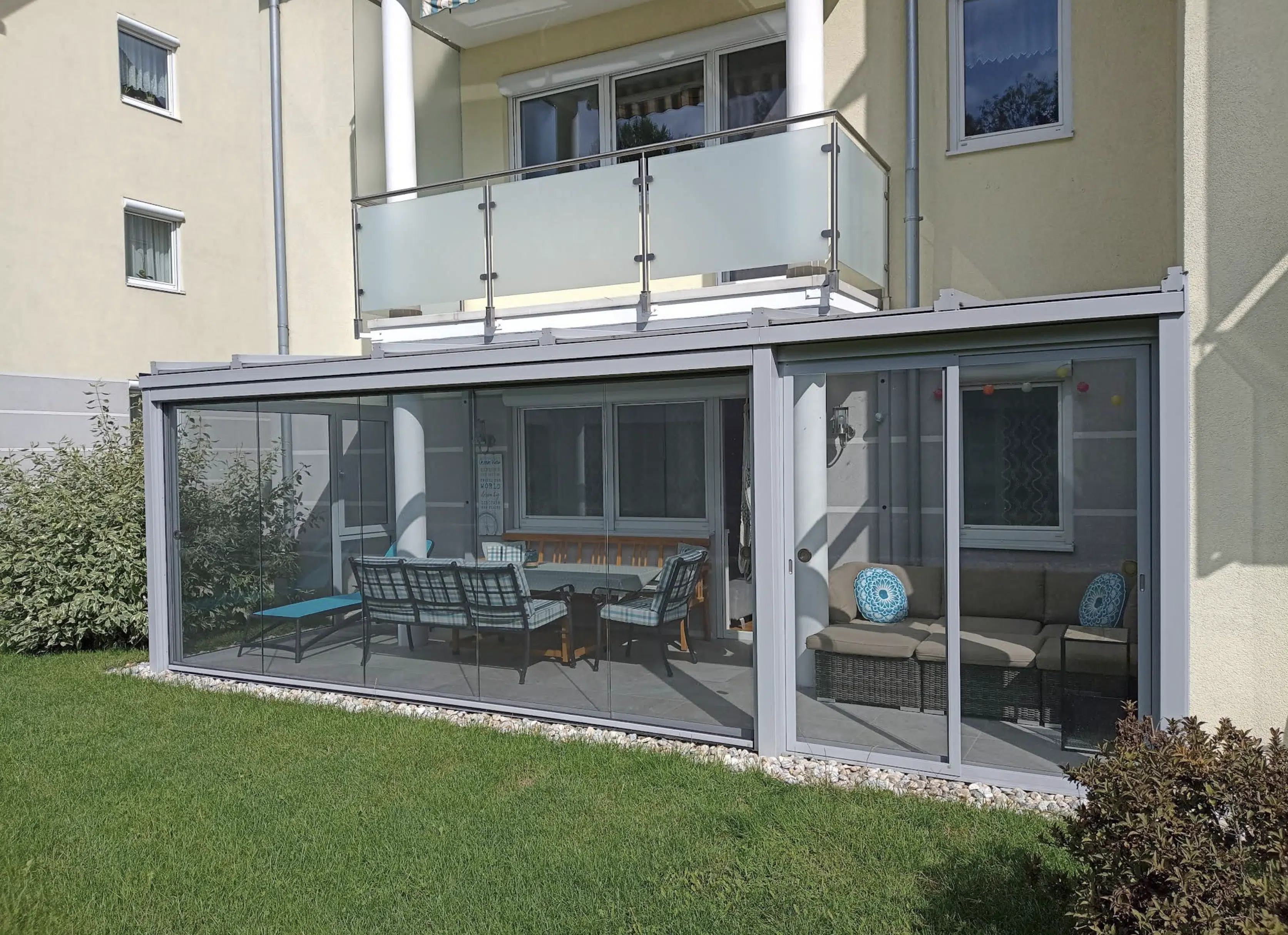 Terrassenverglasung passgenau unter einem bestehenden Balkon eingebaut