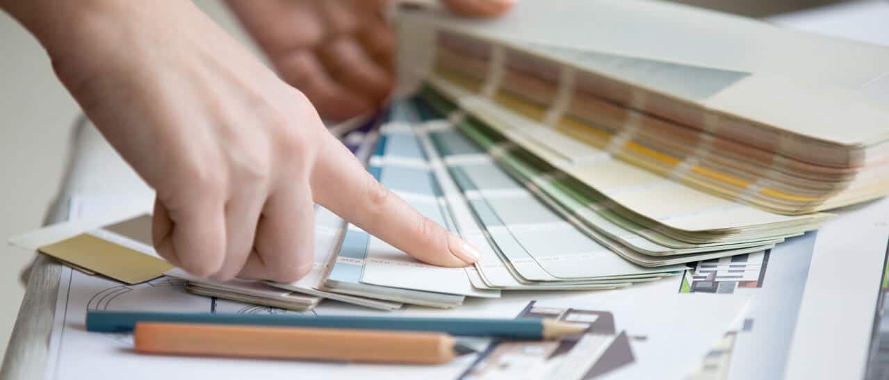 Farben für Wintergärten: Menschliche Hand zeigt RAL-Farbpalette mit über 200 Farboptionen zur Gestaltung von Wintergärten