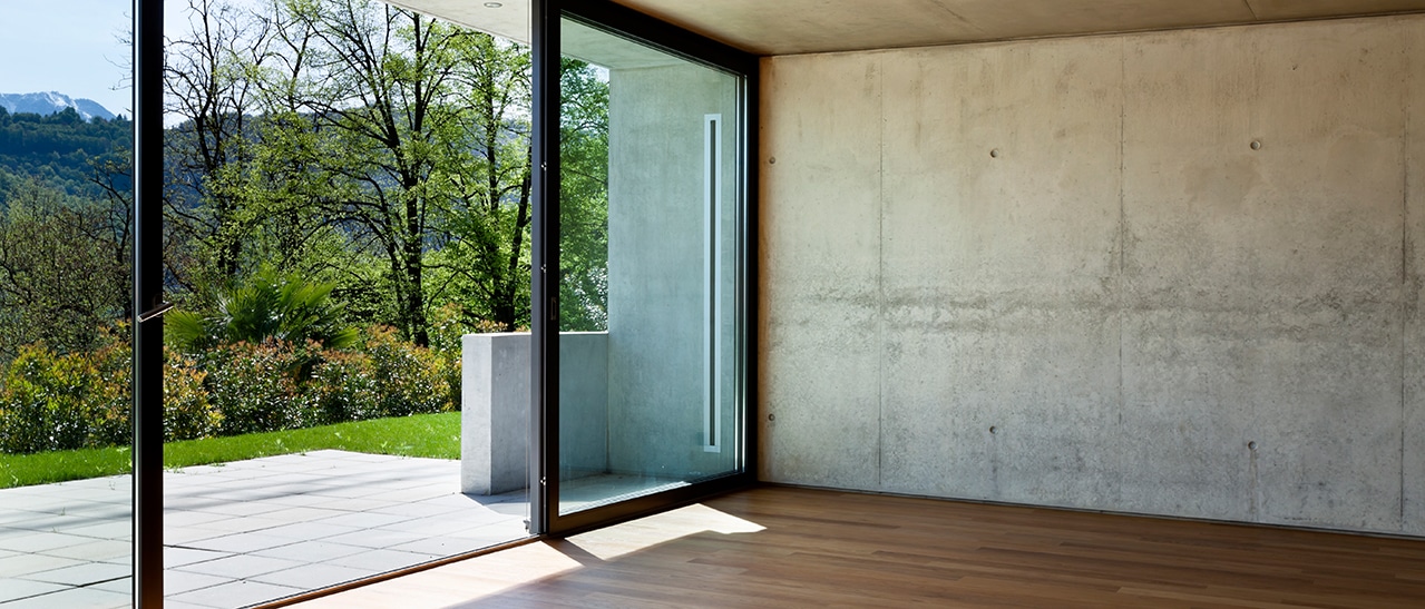 Übergroße Fensterelemente sollten ganz in Aluminium gefertigt werden modernes Wohnzimmer mit großer Glasfront und Aluminiumrahmen zur Terrasse