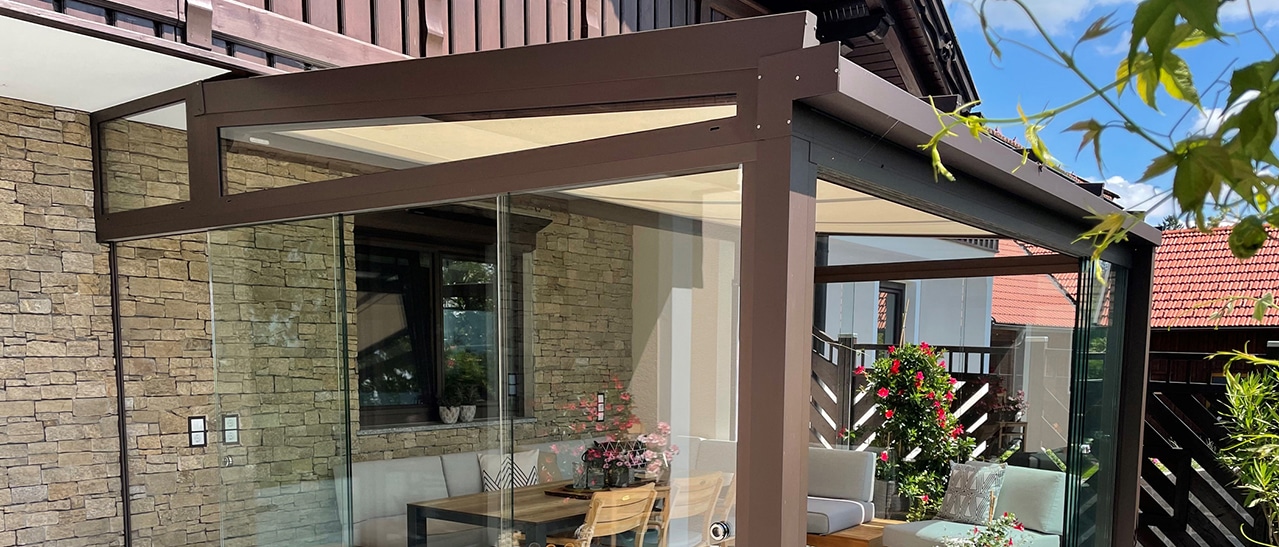 Glasüberdachter Wintergarten mit innenliegender Unterglasmarkise für Sonnenschutz an heißen Tagen.
