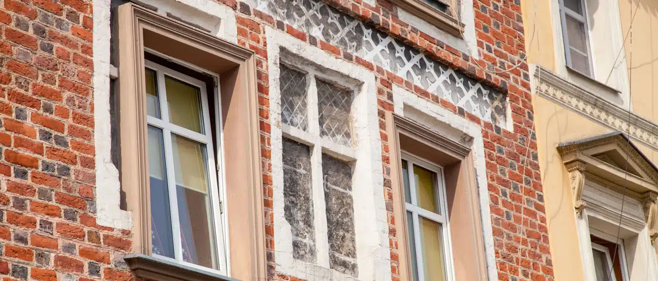 Bild von einem Altbau, wo offensichtliche Fehler bei der Fenstermontage stattgefunden haben. Fenster wurden in ungleichen Höhen verbaut.