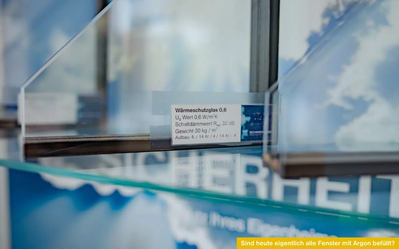 Nahaufnahme von Glasmustern im Querschnitt mit einem Etikett für Wärmeschutzglas 0,6 und technischen Daten.