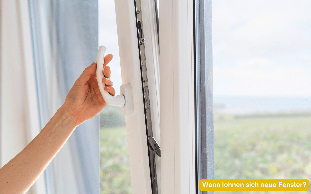 Wann lohnen sich neue Fenster - modernes weißes Fenster wird geöffnet mit weitem Ausblick ins Grüne