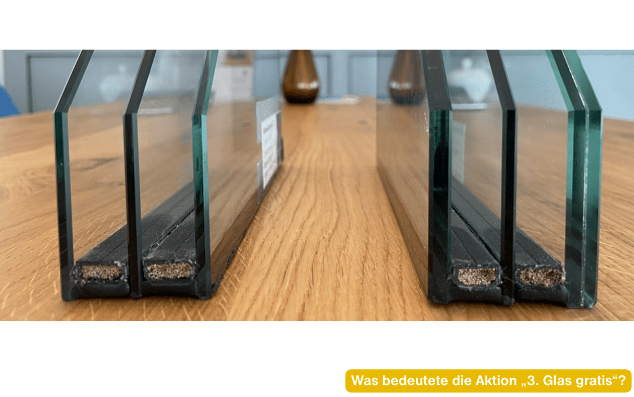 Was bedeutete die Aktion 3. Glas gratis? Zwei Muster von 3-fach-Isolierglas im Schnitt mit Abstandhaltern auf einem Holztisch