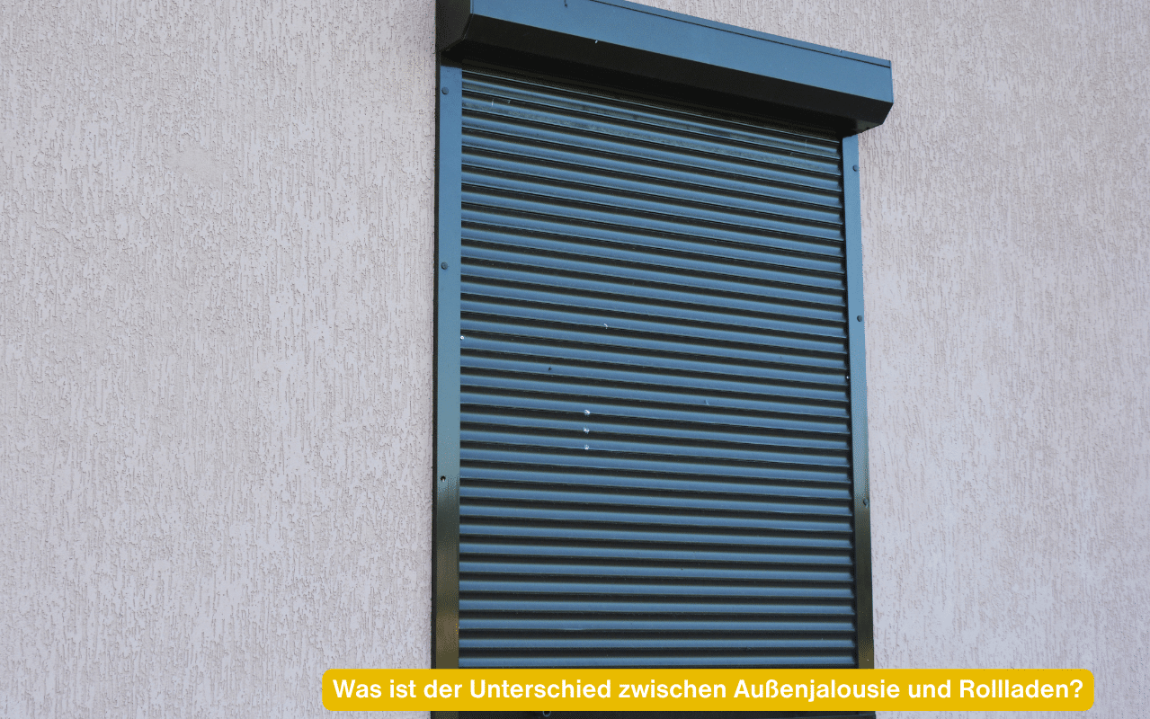 Was ist der Unterschied zwischen Außenjalousie und Rollladen? Geschlossener Rollladen in Anthrazit an einer grauen Fassade