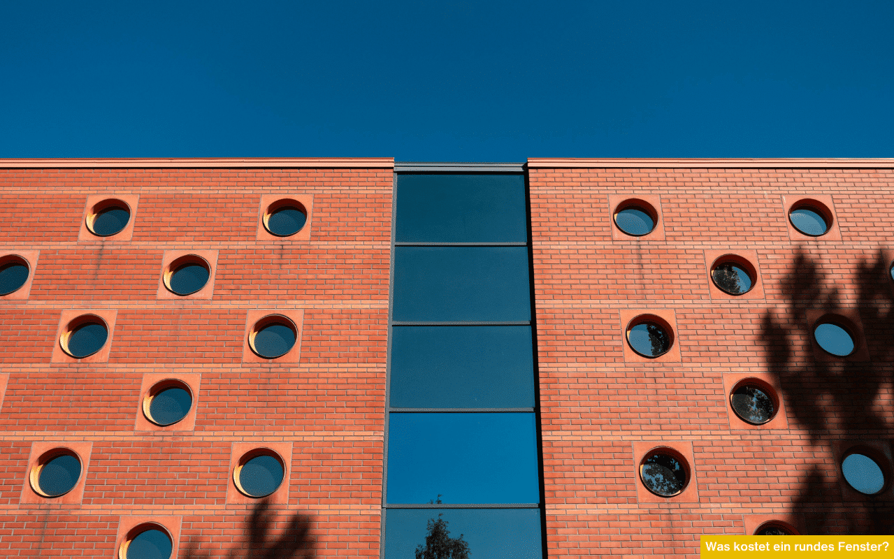 Was kostet ein rundes Fenster? Moderne Backsteinfassade mit runden Fenstern und Mittelverglasung