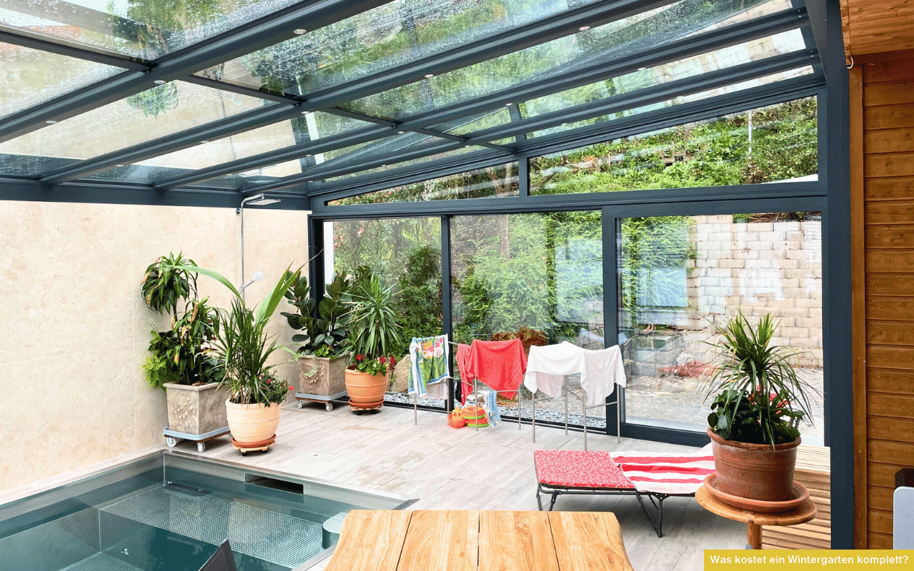 Was kostet ein Wintergarten komplett? Bild zeigt modernen Wintergarten mit Glasdach, Schiebeverglasung, Pflanzen und Poolbereich.