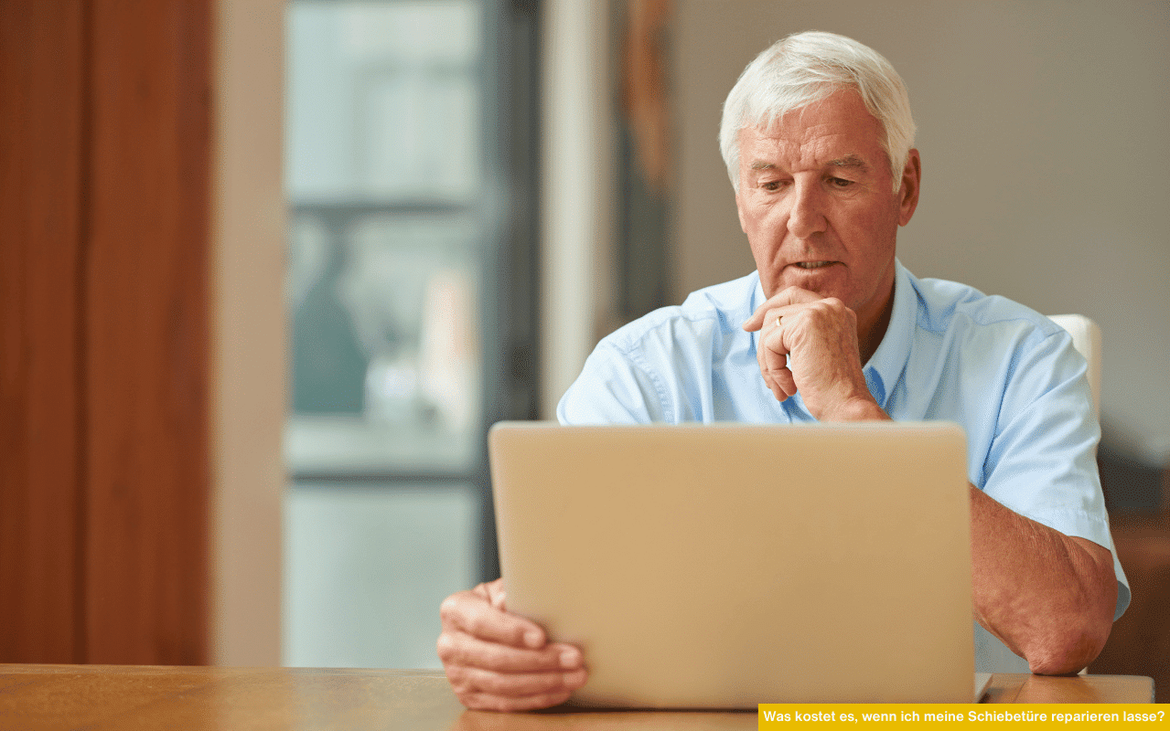 Was kostet es, wenn ich meine Schiebetüre reparieren lasse? Senior vergleicht Reparaturpreise am Laptop im Wohnraum.
