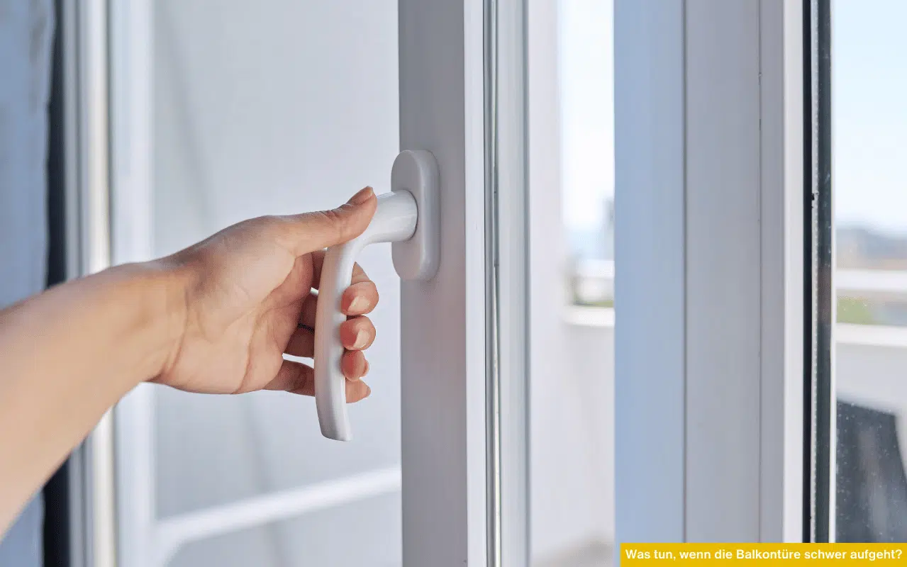 Was tun wenn die Balkontüre schwer aufgeht Hand betätigt weißen Türgriff einer Kunststofftüre und zeigt schwergängiges Öffnen