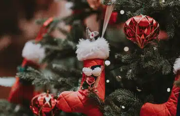 Geschmückter Weihnachtsbaum vor Fenster: Weihnachtsurlaub bei Schmidinger 2022/2023, festliche Stimmung für besinnliche Feiertage.