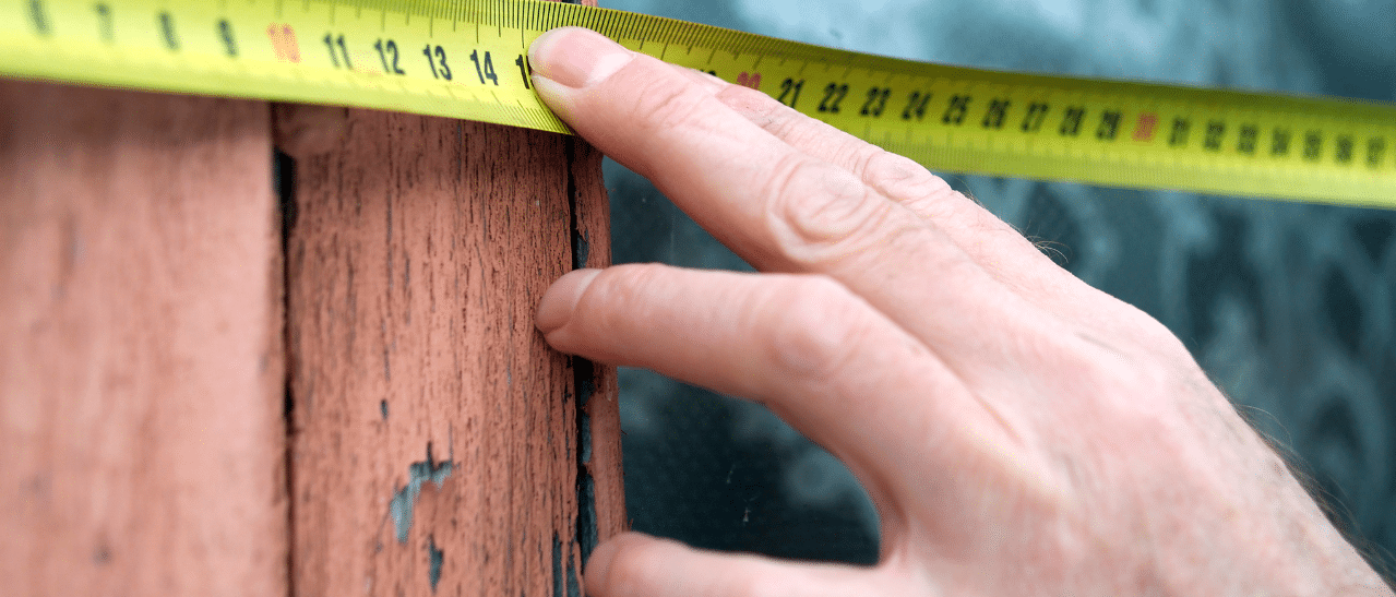 Verkäufer misst bodentiefe Fenster für Altbau, maßgeschneiderte Lösungen verfügbar.
