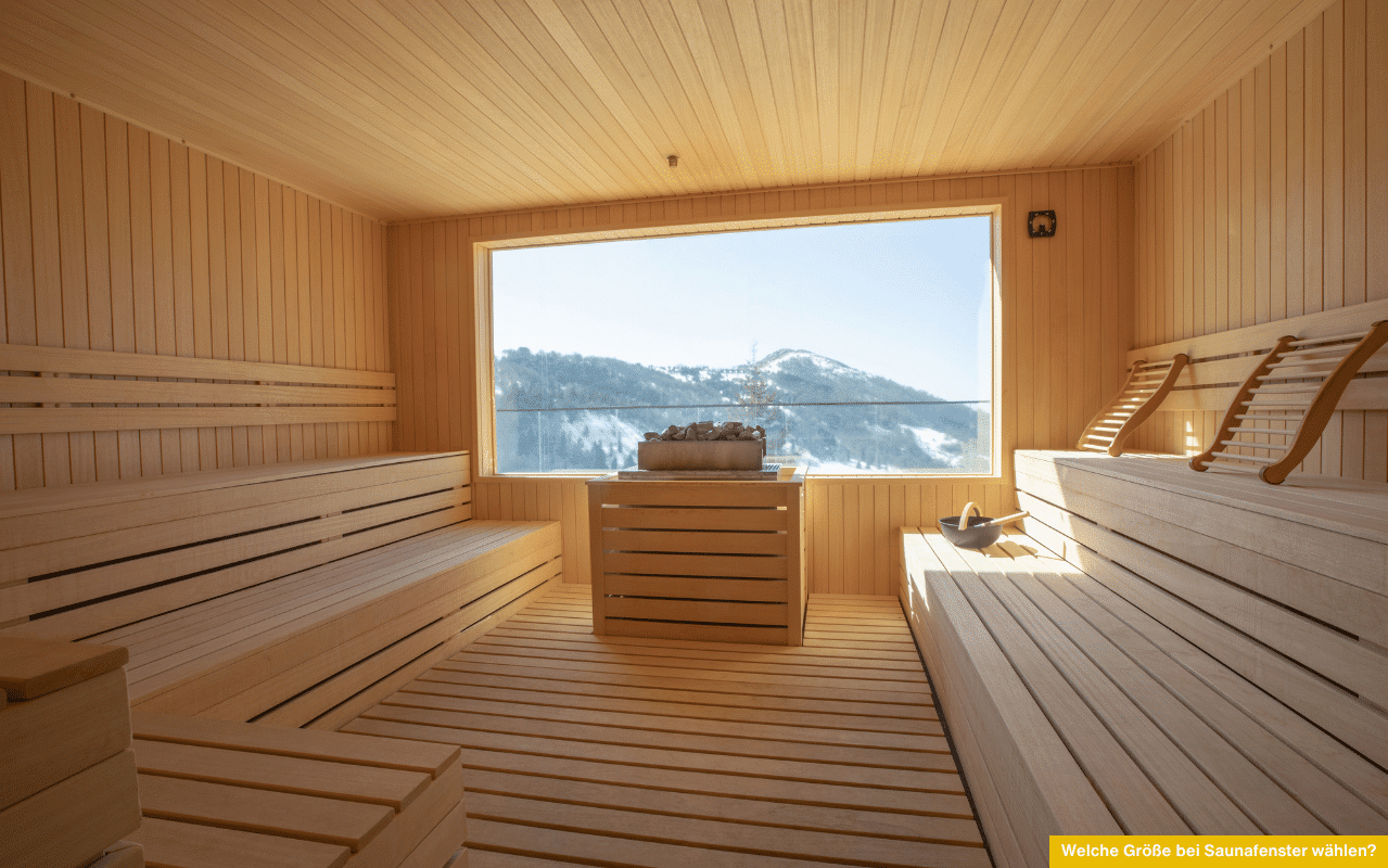 Welche Größe bei Saunafenster wählen? Großes Panoramafenster mit Blick auf verschneite Berge in heller, moderner Holzsauna.
