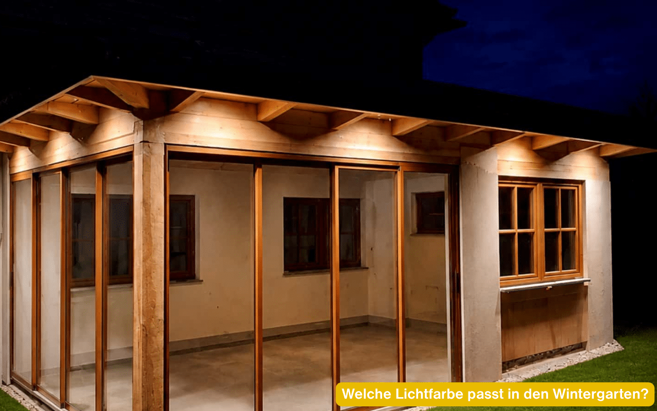Welche Lichtfarbe passt in den Wintergarten? Holzkonstruktion mit Glasschiebeelementen am Abend in warmweißem Licht