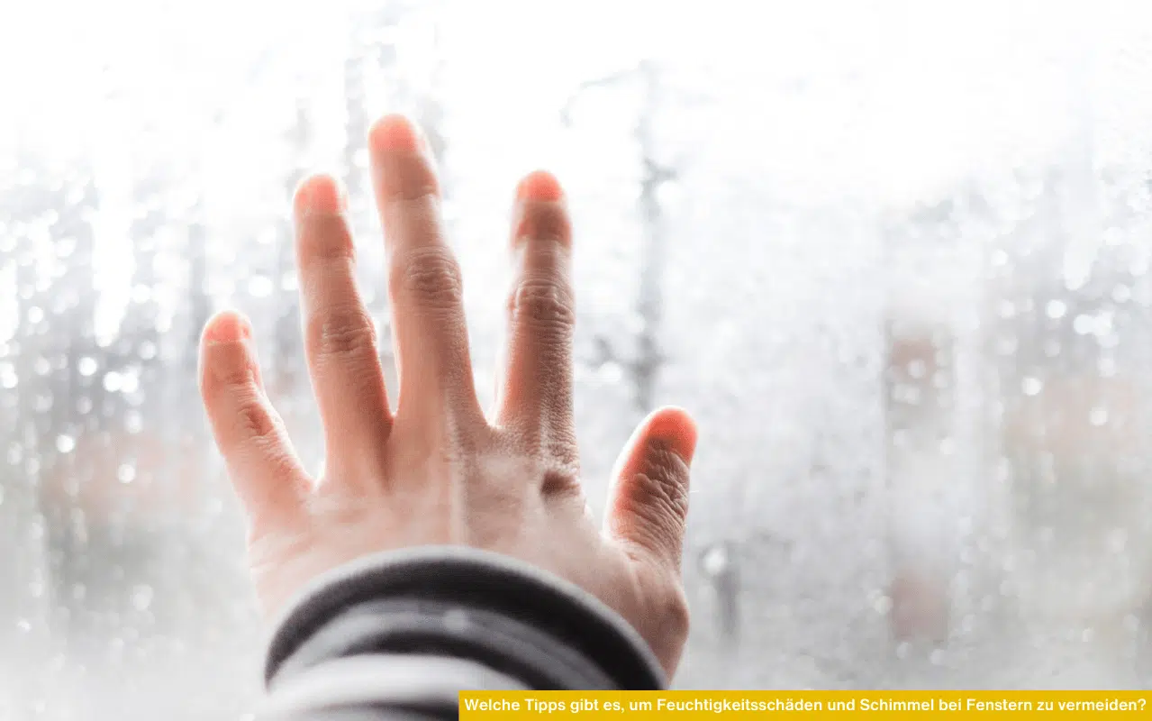 Welche Tipps gibt es, um Feuchtigkeitsschäden und Schimmel bei Fenstern zu vermeiden? Hand am beschlagenen Fenster