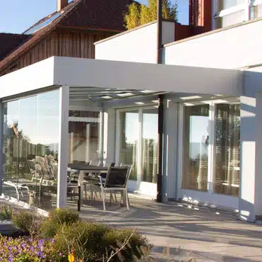 Moderne Wintergarten-Türen Oberösterreich – große Glasflächen verbinden Wohnraum und Terrasse mit lichtdurchflutetem Anbau