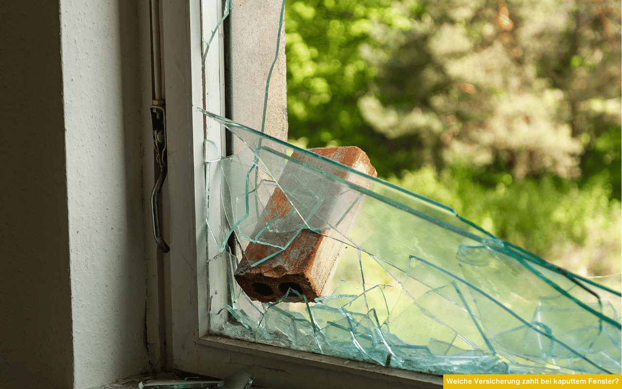 Welche Versicherung zahlt bei kaputtem Fenster? Ziegelstein liegt in eingeschlagener Fensterscheibe, Glassplitter überall verteilt.
