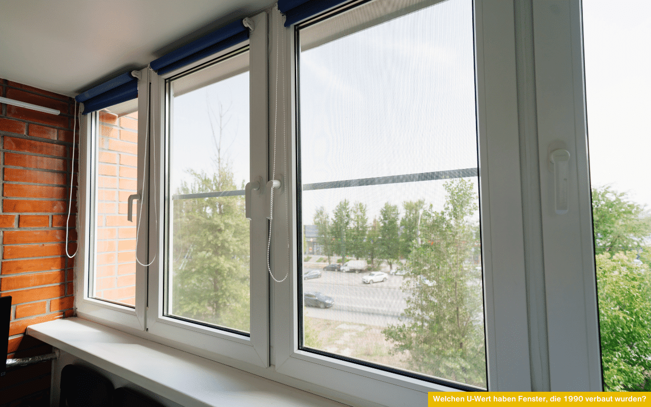 Welchen U-Wert haben Fenster, die 1990 verbaut wurden zeigt ältere Kunststofffenster mit Blick ins Grüne und auf eine Straße.