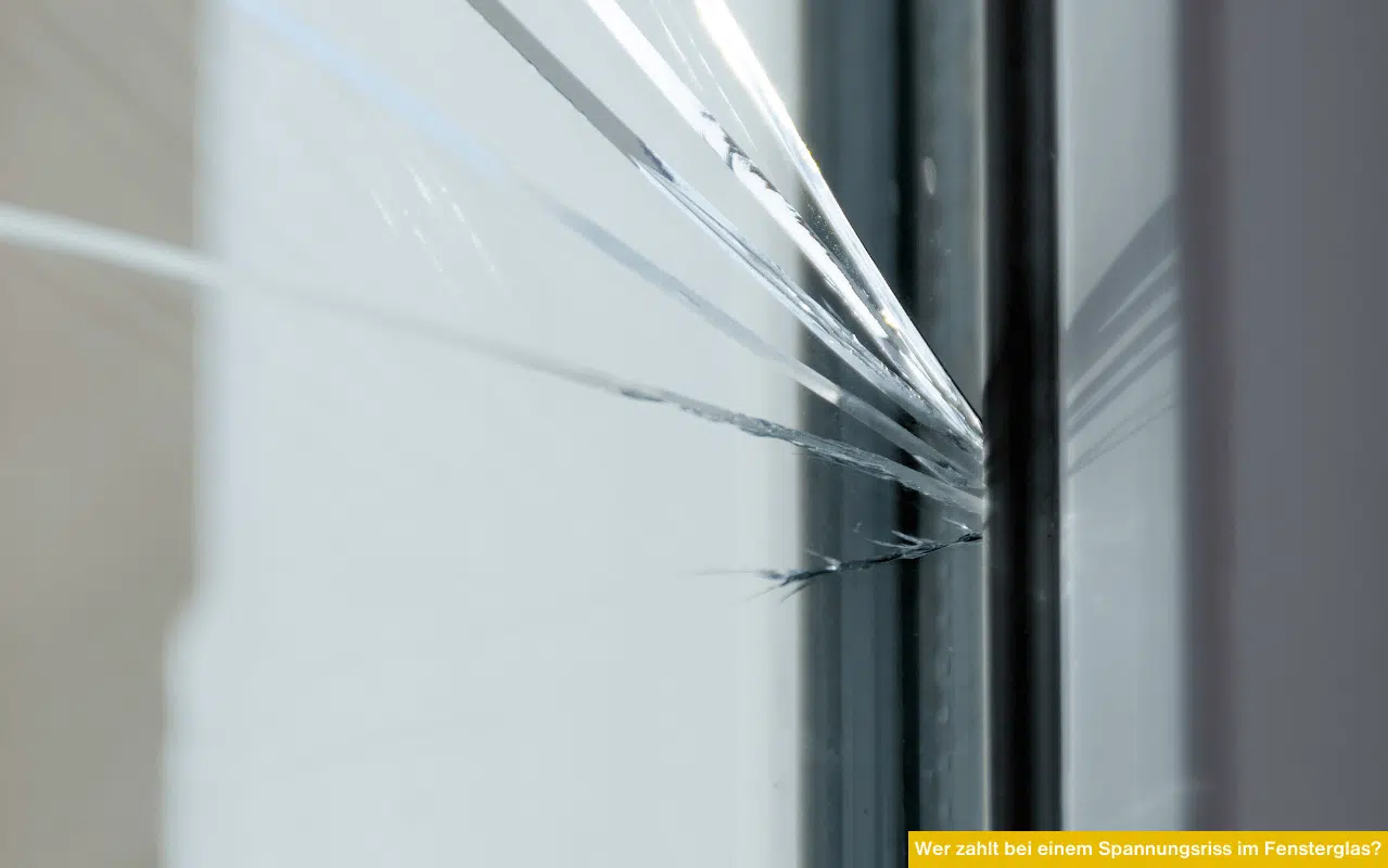 Wer zahlt bei einem Spannungsriss im Fensterglas zeigt Nahaufnahme eines gerissenen Fensterglases mit sichtbaren Spannungslinien.
