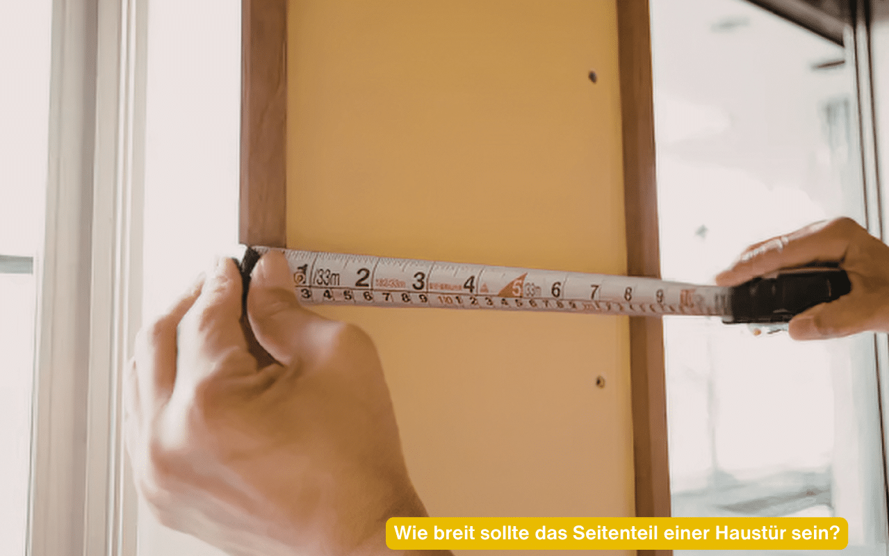 Wie breit sollte das Seitenteil einer Haustür sein? Hände messen mit Maßband die Breite an einer Tür