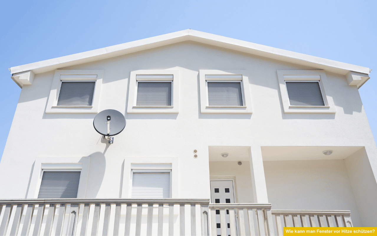 Wie kann man Fenster vor Hitze schützen? Hier ein Beispiel, welches geschlossene Rollläden an weißem Einfamilienhaus bei direkter Sonneneinstrahlung zeigt.