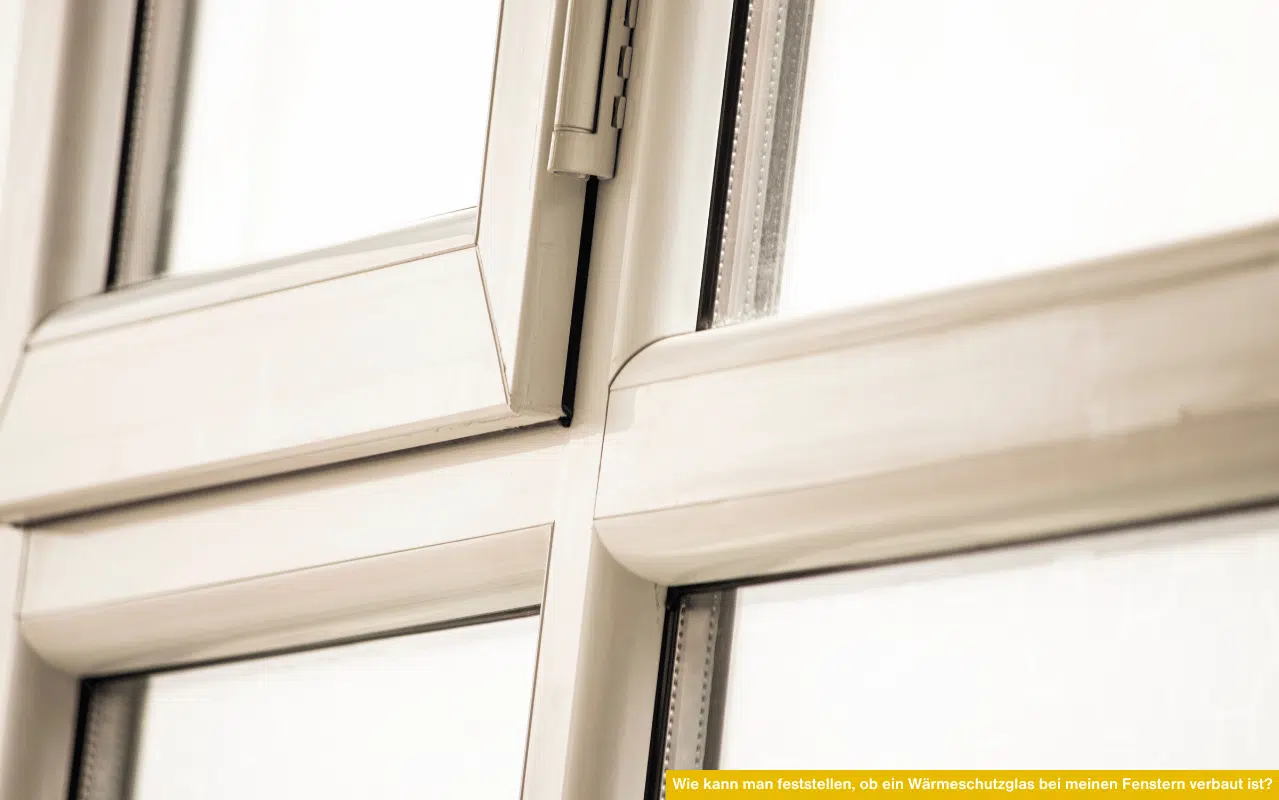 Wie kann man feststellen, ob ein Wärmeschutzglas bei meinen Fenstern verbaut ist, zeigt Nahaufnahme eines älteren Kunststofffensters