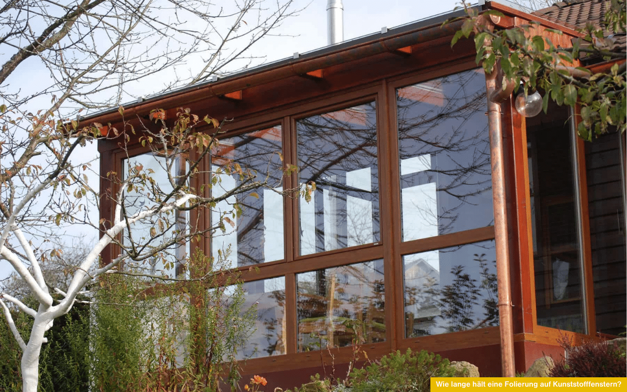 Wie lange hält eine Folierung auf Kunststofffenstern zeigt Wintergarten mit großflächigen Fensterflächen und gepflegtem Rahmen in Holzoptik.