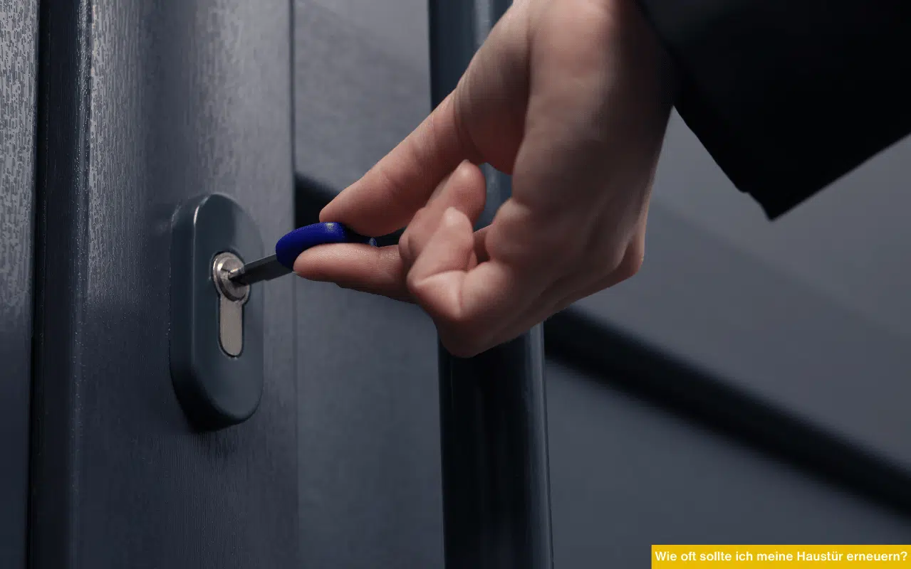 Wie oft sollte ich meine Haustür erneuern Hand dreht Schlüssel im Schloss einer modernen Haustür