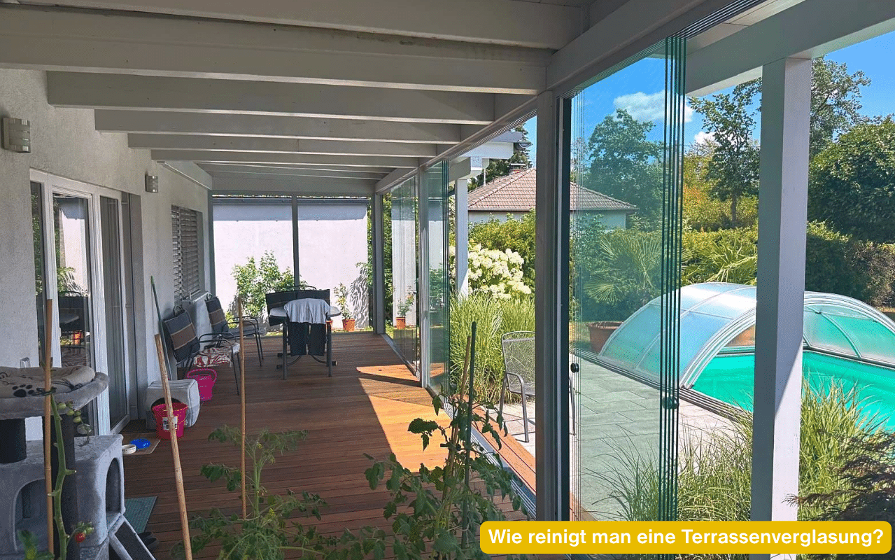 Wie reinigt man eine Terrassenverglasung? Glasschiebeelemente unter einem Holzdach von innen mit Blick auf den Pool