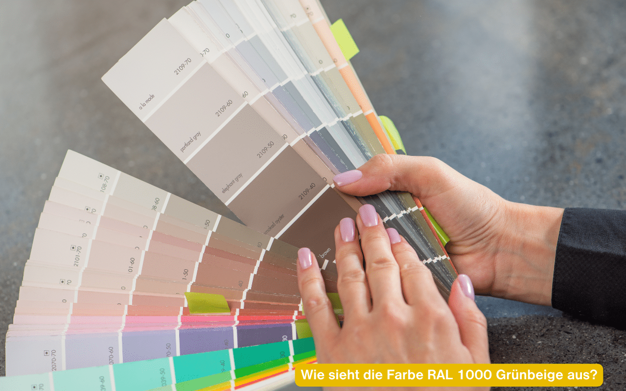 Wie sieht die Farbe RAL 1000 Grünbeige aus? Hand hält einen Fächer mit hellen Beige- und Grau-Farbmustern