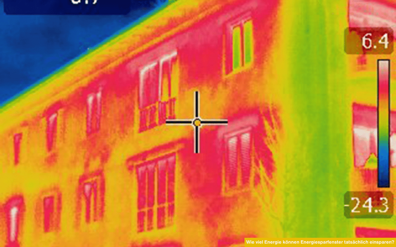 Das Bild zeigt eine farbige Wärmebildaufnahme eines Gebäudes. Rote Bereiche markieren hohe Wärmeverluste, während blaue und grüne Zonen auf gut gedämmte Fenster und Wände hinweisen.