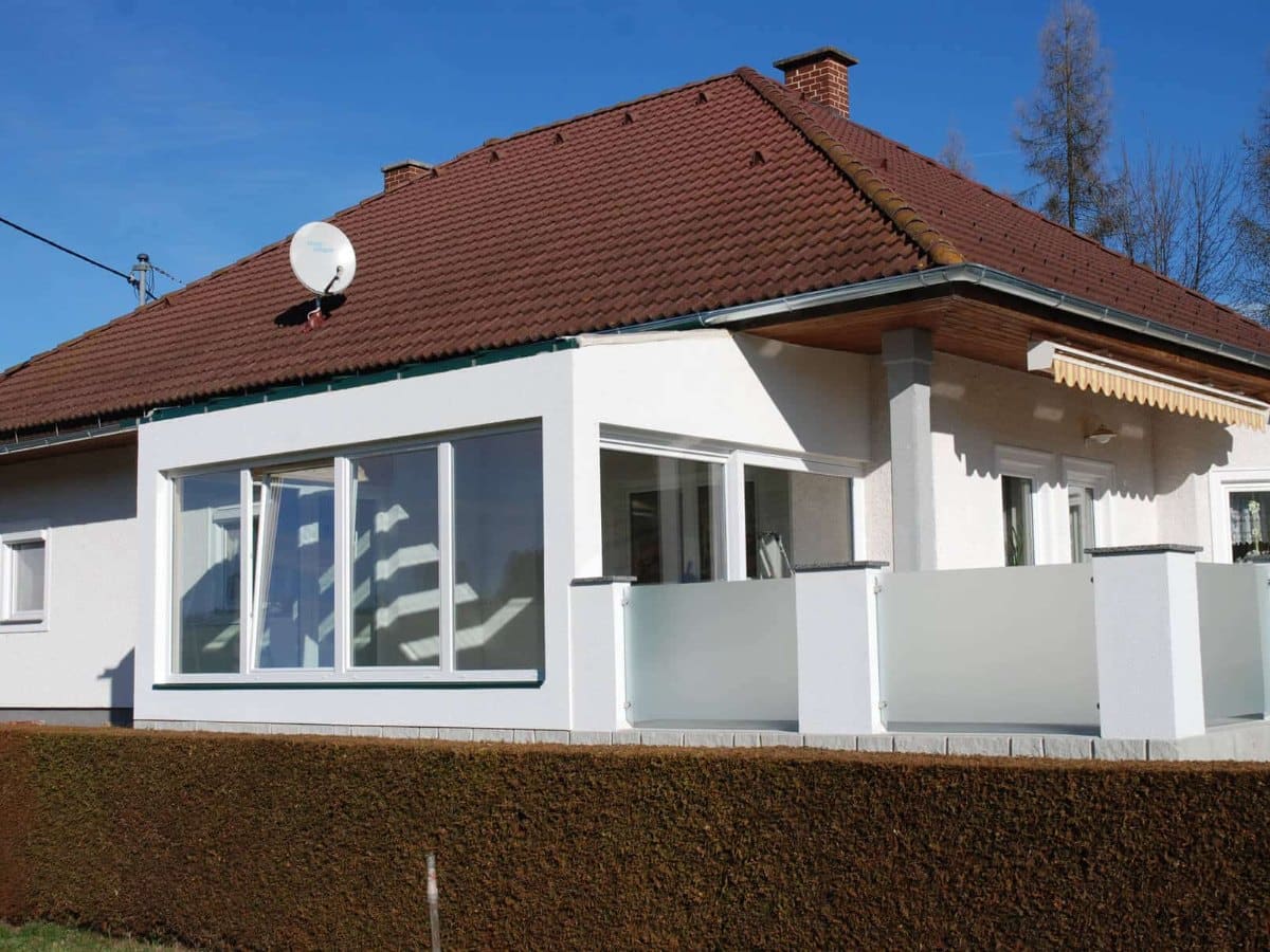Wintergarten-Anbau mit weißen Kunststoff-Elementen an einem Einfamilienhaus